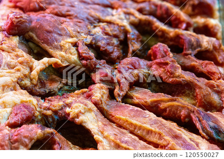 Pork dried meat jerky close-up background, top view. 120550027