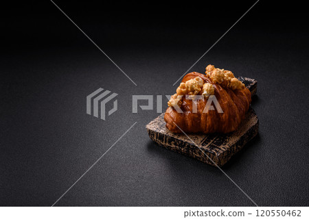 Sweet crispy croissant with salted caramel and glazed popcorn 120550462