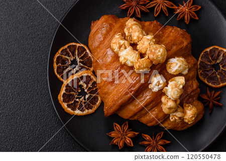 Sweet crispy croissant with salted caramel and glazed popcorn Sweet crispy croissant with salted caramel and glazed popcorn 120550478