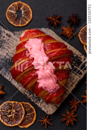 Crispy fresh red croissant with cream and strawberries Crispy fresh red croissant with cream and strawberries 120550751