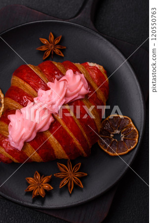 Crispy fresh red croissant with cream and strawberries 120550763