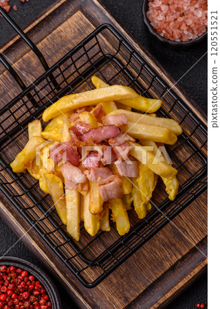 Crispy French fries with pieces of bacon, salt and spices Crispy French fries with pieces of bacon, salt and spices 120551521