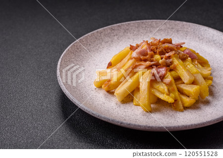 Crispy French fries with pieces of bacon, salt and spices 120551528