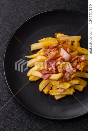 Crispy French fries with pieces of bacon, salt and spices Crispy French fries with pieces of bacon, salt and spices 120551539