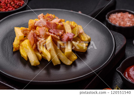 Crispy French fries with pieces of bacon, salt and spices 120551540