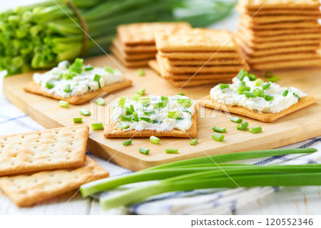 Cheese dip with savory biscuit and and spring onions on a kitchen table, selective focus. 120552346