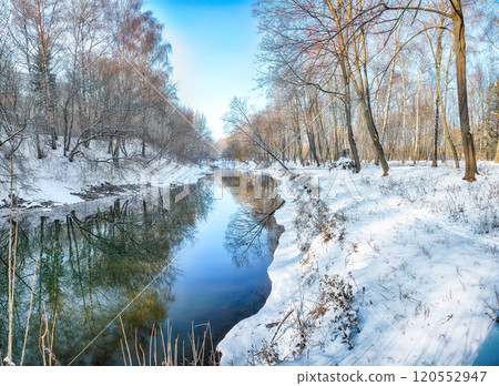 Fabulous landscape in city park with snowy trees and beautiful frozen river. Fabulous landscape in city park with snowy trees and beautiful frozen river. 120552947