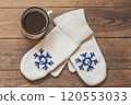 iron mug with coffee and knitted mittens on the wooden floor. Winter concept 120553033