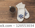 iron mug with coffee and knitted mittens on the wooden floor. Winter concept 120553034
