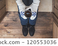 A girl in the boots with an iron mug of coffee on the terrace of a wooden house. concept 120553036