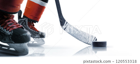 Hockey skates, puck and stick close-up. Hockey player in ice rink. Focus on the puck. Isolated. Hockey concept Hockey skates, puck and stick close-up. Hockey player in ice rink. Focus on the puck. Isolated. Hockey concept 120553318