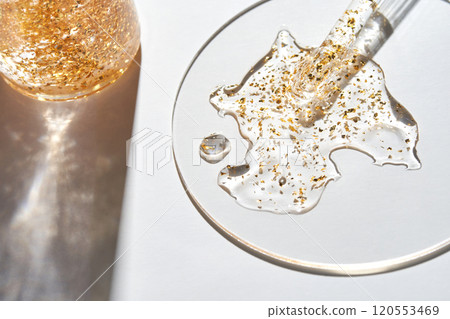 Golden skincare elixir with dropper on glass plate in sunlight for luxurious Golden skincare elixir with dropper on glass plate in sunlight for luxurious 120553469