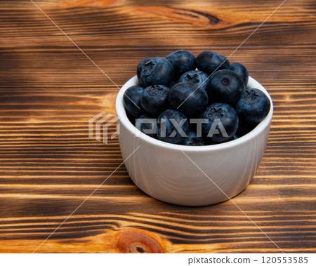 Fresh blueberry in white dish on wooden background 120553585
