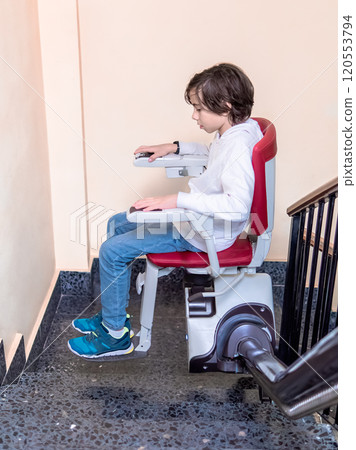 Child Using Stairlift on Indoor Staircase 120553794