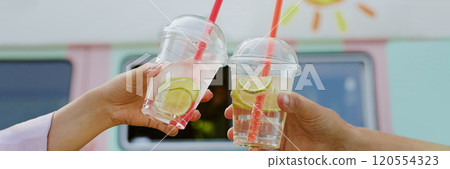 Website banner with unrecognizable couple clinking transparent plastic gups with citrus lemonade and slices of lime inside Website banner with unrecognizable couple clinking transparent plastic gups with citrus lemonade and slices of lime inside 120554323