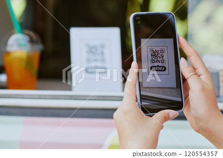 Medium close up of unrecognizable woman scanning QR code to read menu 120554357
