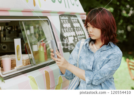 Asian beautiful female customer scanning QR code to pay for order Asian beautiful female customer scanning QR code to pay for order 120554410