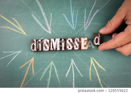 Dismissed. Wooden letters and arrows on a green chalk board 120555622