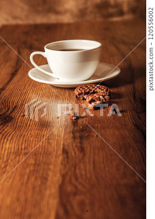 Cup glass of coffee with smoke and coffee beans on old wooden background.Delicious chocolate chip cookies with a cup of coffee 120556002
