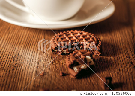 Cup glass of coffee with smoke and coffee beans on old wooden background.Delicious chocolate chip cookies with a cup of coffee 120556003