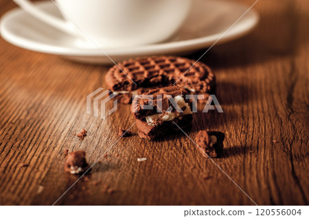 Cup glass of coffee with smoke and coffee beans on old wooden background.Delicious chocolate chip cookies with a cup of coffee Cup glass of coffee with smoke and coffee beans on old wooden background.Delicious chocolate chip cookies with a cup of coffee 120556004