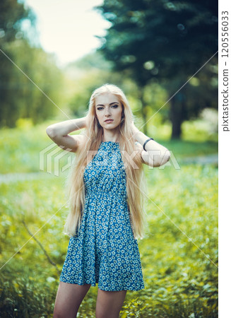 Beauty blonde with long and shiny long hair. The woman is stylish in a blue dress. Fashion. Beauty blonde with long and shiny long hair. The woman is stylish in a blue dress. Fashion. 120556033