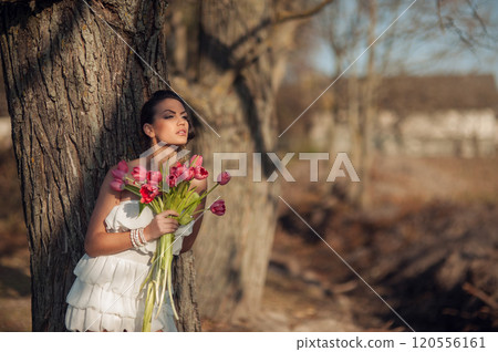 Girl with a spring bouquet of rose.Sexy brunette in a white short dress. Girl with a spring bouquet of rose.Sexy brunette in a white short dress. 120556161
