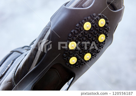 Cleats or crampons that have metal spikes for extra traction on ice, winter walking is safer. 120556187
