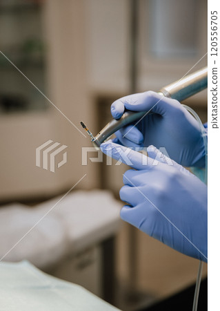 Dentist holding a dental drill with implant, ready for precise dental procedures in a clinic 120556705