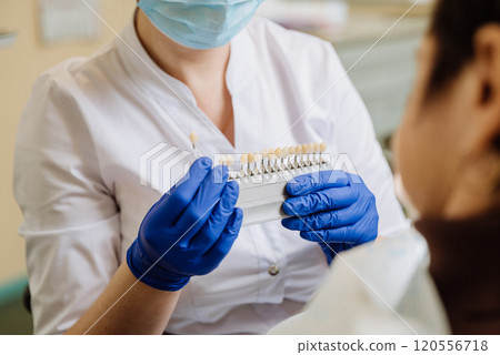 Dentist selecting a shade for dental veneers to ensure a perfect match for the patient's teeth Dentist selecting a shade for dental veneers to ensure a perfect match for the patient's teeth 120556718