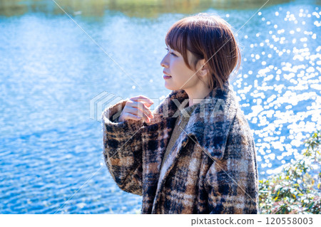 Young woman strolling through the autumn/winter park 120558003