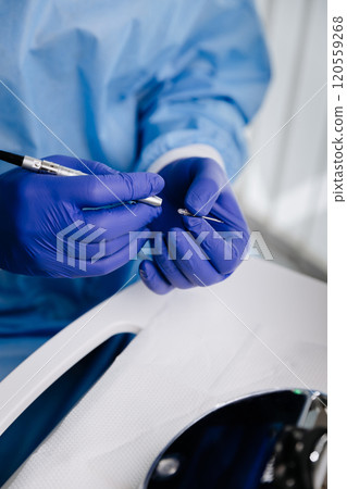Dentist using precision tool on sterile gloves during dental procedure preparation Dentist using precision tool on sterile gloves during dental procedure preparation 120559268