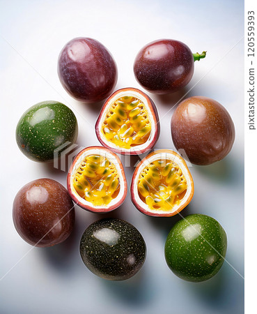 Vibrant passion fruits, one halved revealing juicy seeds, against a white backdrop 120559393