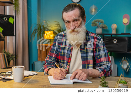 POV shot of senior man looking to camera listening to colleague talking writing down notes on diary POV shot of senior man looking to camera listening to colleague talking writing down notes on diary 120559619
