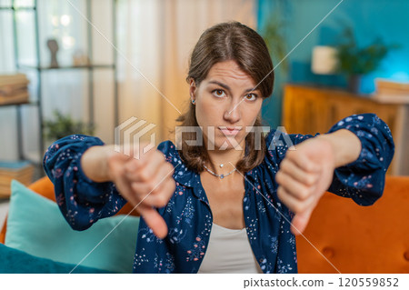 Upset unhappy young woman showing thumbs down sign dislike gesture disapproval bad work feedback 120559852