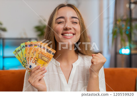 Successful rich happy smiling woman holding waving euro bills money fan winning online lottery game Successful rich happy smiling woman holding waving euro bills money fan winning online lottery game 120559920