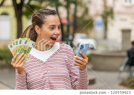 Happy woman counting money euro cash, use smartphone calculator app in urban city street 120559923