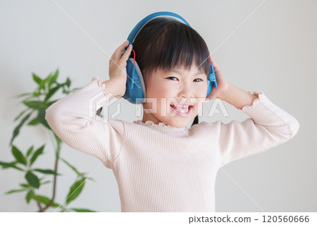 Hearing-impaired child wearing earmuffs 120560666