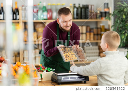 Male seller offers cookies to boy buyer Male seller offers cookies to boy buyer 120561622