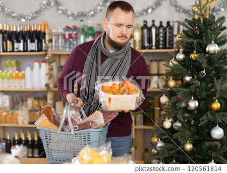 Young man choosing tangerines at grocery store Young man choosing tangerines at grocery store 120561814