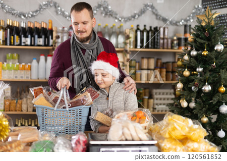 Dad and son are choosing sweets for New Year celebration in supermarket Dad and son are choosing sweets for New Year celebration in supermarket 120561852