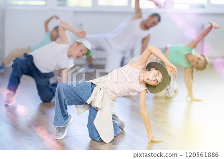 Preteen boys and girls studying movement of contemporary dance in classroom with his friends 120561886