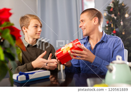 Man giving Christmas present to his son Man giving Christmas present to his son 120561889