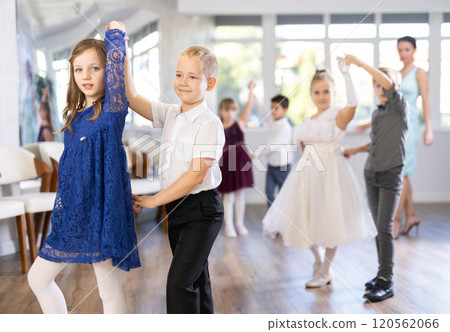 Little children in elegant dresses practicing waltz dance in school hall Little children in elegant dresses practicing waltz dance in school hall 120562066