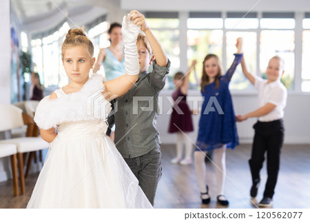 Little children in elegant dresses practicing waltz dance in school hall Little children in elegant dresses practicing waltz dance in school hall 120562077