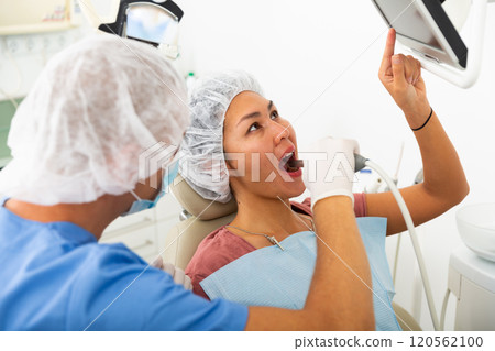 Dentist uses modern equipment and a computer to check patient teeth Dentist uses modern equipment and a computer to check patient teeth 120562100