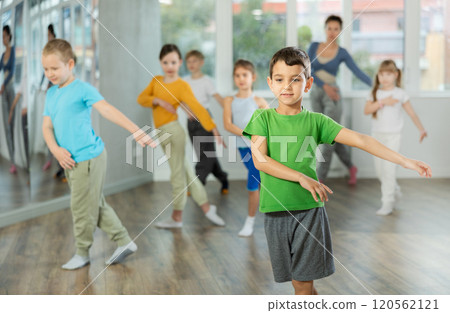 Group of happy preteen children with female teacher practicing hip hop in dance studio 120562121