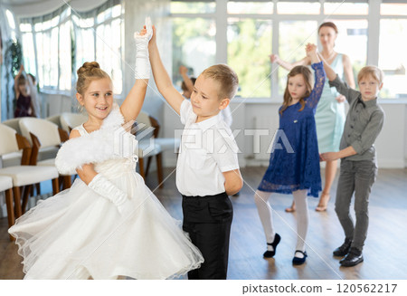 Enthusiastic preteen children dancing waltz in pairs in dance school Enthusiastic preteen children dancing waltz in pairs in dance school 120562217