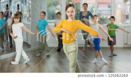 Children training modern dance moves together in studio under the guidance of teacher 120562269