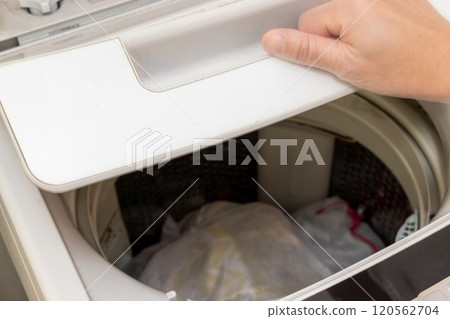 Open the lid of the washing machine Open the lid of the washing machine 120562704